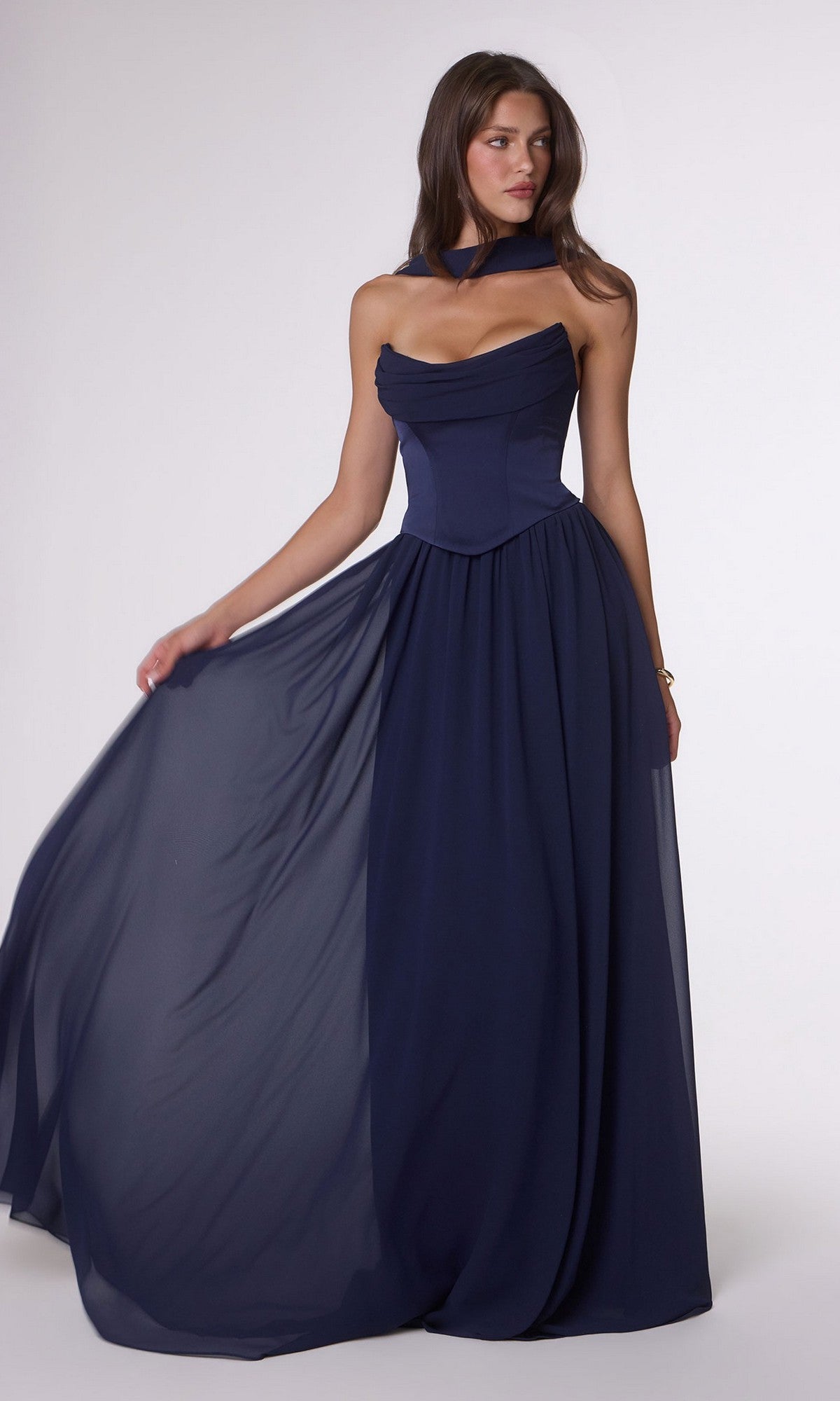 Model wearing the Amoris T741 long prom dress with a satin corset bodice and flowing navy blue chiffon A-line skirt, paired with a matching neckpiece, set against a plain light background.
