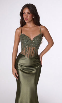 A woman wears the Lace-Up Long Corset Prom Dress: Amoris T819, a fitted olive green gown with a beaded sheer bodice and thin straps, standing against a plain light background.