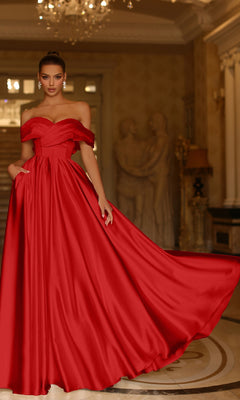 A woman in the Bow-Back Long Prom Ball Gown, Tina Holly TE207, stands gracefully in an elegant room adorned with statues and chandeliers.