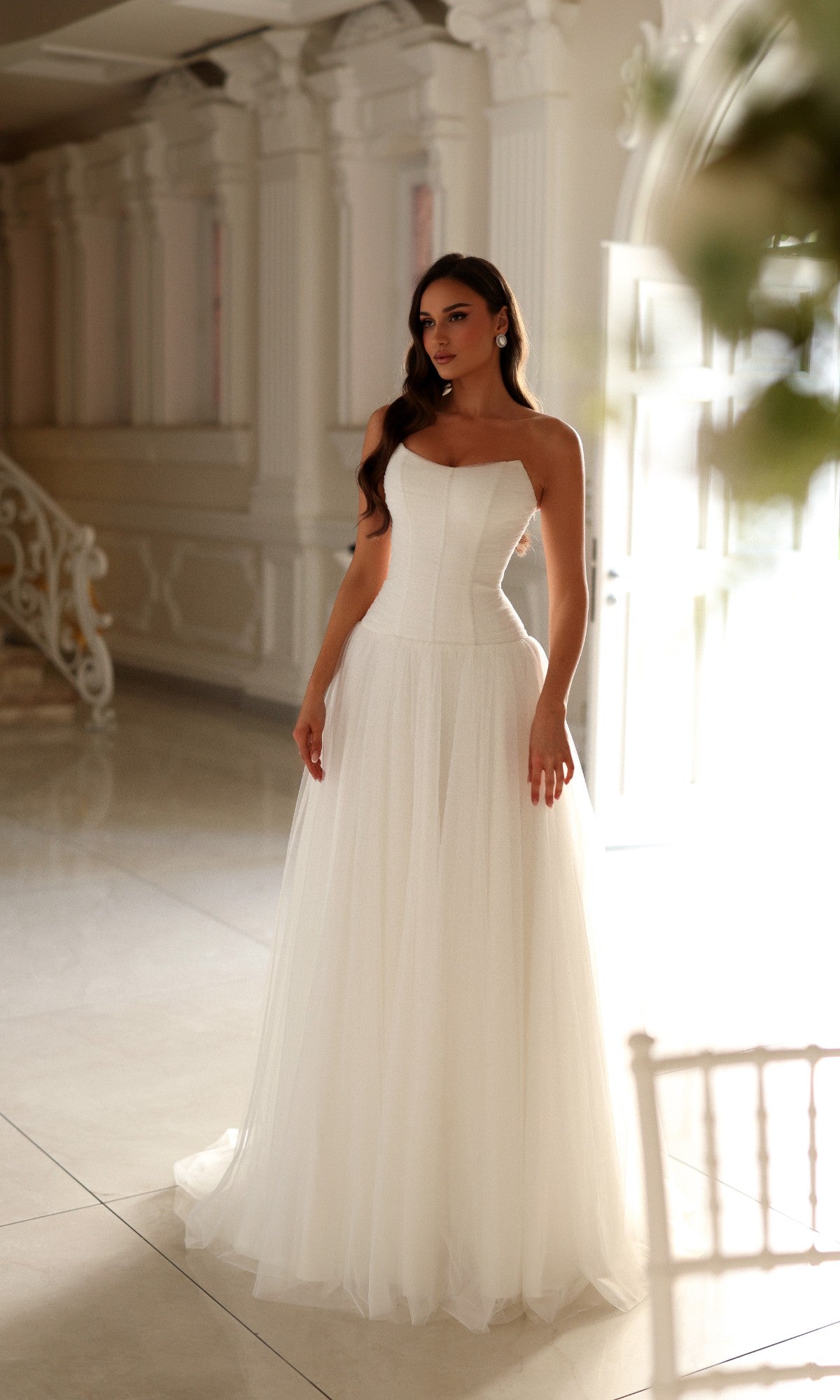 Tina Holly TE710 long wedding dress in off-white featuring a strapless, floor-length design with a fitted corset bodice and a full tulle skirt.