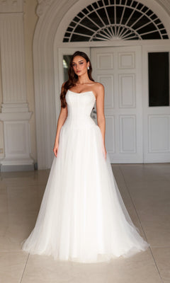 Tina Holly TE710 floor-length white wedding dress with a strapless corset bodice and a full tulle skirt.