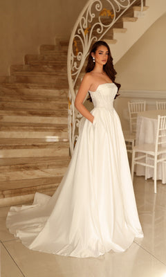Tina Holly TE711 long wedding dress featuring a strapless A-line silhouette with a fitted bodice and a floor-length, full skirt with pockets.