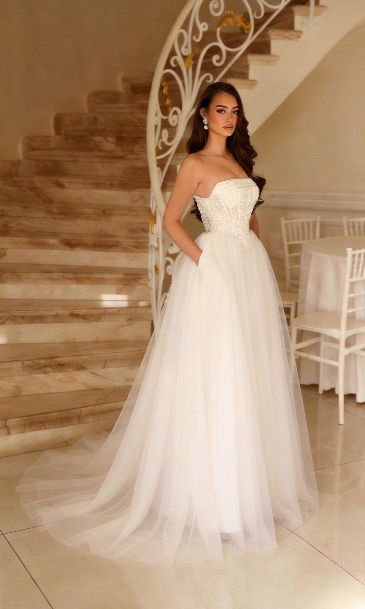 The Long Wedding Dress: Tina Holly TE713 is a strapless, floor-length bridal gown with a structured lace bodice and a full, A-line tulle skirt featuring pockets.