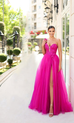 A woman in the Tina Holly TK554 One-Shoulder Glitter Prom Gown stands outdoors near a building, holding a pink flower and smiling at the camera.