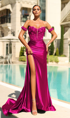A woman in the Lace-Corset Strapless Prom Gown: Tina Holly TK583, featuring a vibrant magenta hue, floral details, and a high slit, stands poolside before a modern building.