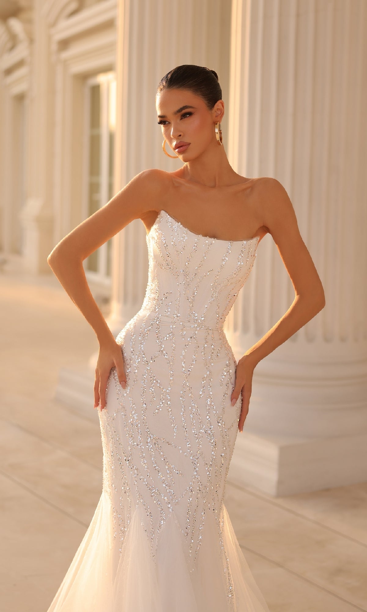 Woman wearing the Strapless Long Glitter Prom Gown: Tina Holly TK807, posing outdoors in front of tall columns.