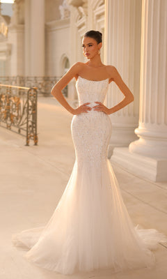 A woman in the Strapless Long Glitter Prom Gown: Tina Holly TK807 stands in an elegant, columned outdoor setting.