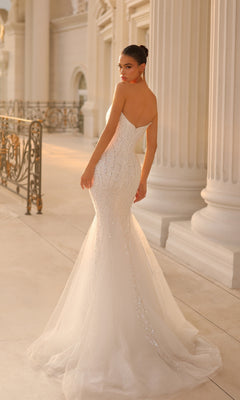 Wearing the Strapless Long Glitter Prom Gown Tina Holly TK807, a woman stands near ornate railings and white columns, looking over her shoulder.
