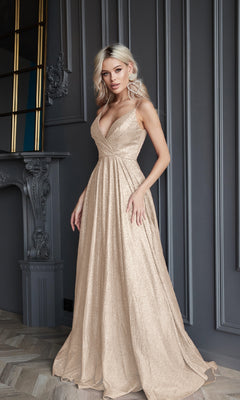 A woman with long blonde hair wears the Tina Holly TW079 Long Glitter A-Line Prom Dress in shimmering beige, standing in an elegant room with ornate grey paneling and a decorative fireplace.