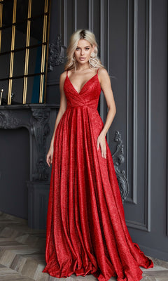 A woman poses indoors in the Tina Holly TW079 Long Glitter A-Line Prom Dress, featuring a floor-length pleated skirt and deep V-neck, in front of an ornate gray wall and mantle.