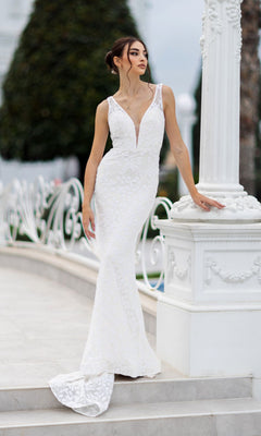 A woman in the Tina Holly TW108 long white sequin formal dress stands outdoors beside a white column, looking to the side.
