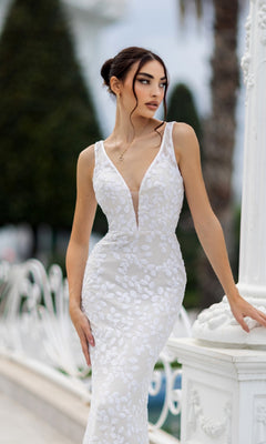 A woman poses outdoors against a white decorative railing and greenery, wearing the Tina Holly TW108 long white sequin formal dress.