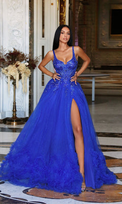 A woman in a royal blue Tina Holly TW610 long prom dress with a sheer corset bodice and thigh-high slit stands indoors, hands on her hips.