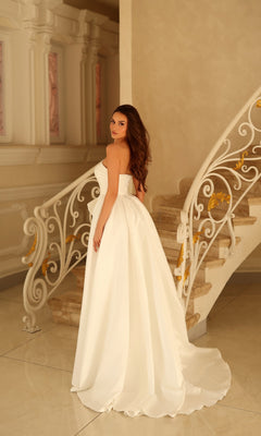 A woman wearing a Tina Holly TW621 long A-line wedding dress standing on a staircase.