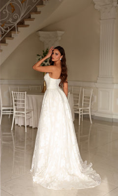 Tina Holly TW623 strapless, floor-length A-line bridal gown in organza jacquard with a floral pattern and a small train.