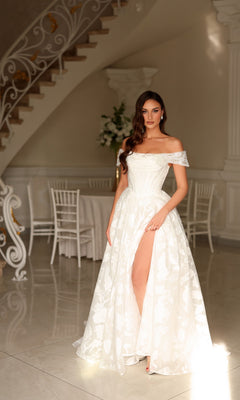 Woman wearing a Tina Holly TW623 long wedding dress featuring an off-the-shoulder floral design and a high leg slit.