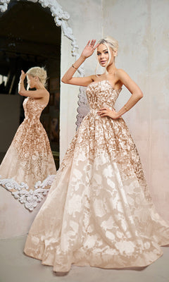 A woman in the Long Formal Dress: Tina Holly TW624, a floor-length floral champagne gown, poses by an ornate mirror with her reflection visible in the background.