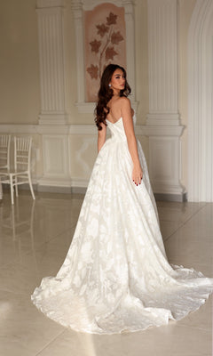 Tina Holly TW627 strapless white organza jacquard wedding dress with a floral pattern and a full, floor-length A-line skirt with a train.