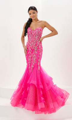 A woman stands against a white background wearing the Long Prom Dress 16057 by Tiffany, a strapless bright pink mermaid gown featuring a sweetheart neckline, silver embellishments, and a layered tulle hem.