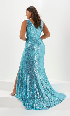 A woman stands on a white platform, seen from the back, wearing the Tiffany Plus-Size V-Neck Sequin Prom Dress 16130—a floor-length blue gown with a flared train, sleeveless design, and side slit.
