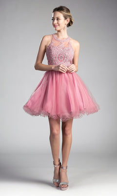 A woman in the High-Neck Short Babydoll Homecoming Dress UJ0119, featuring a sleeveless pink tulle skirt and beaded bodice, pairs it with silver heels while standing against a plain gray background.