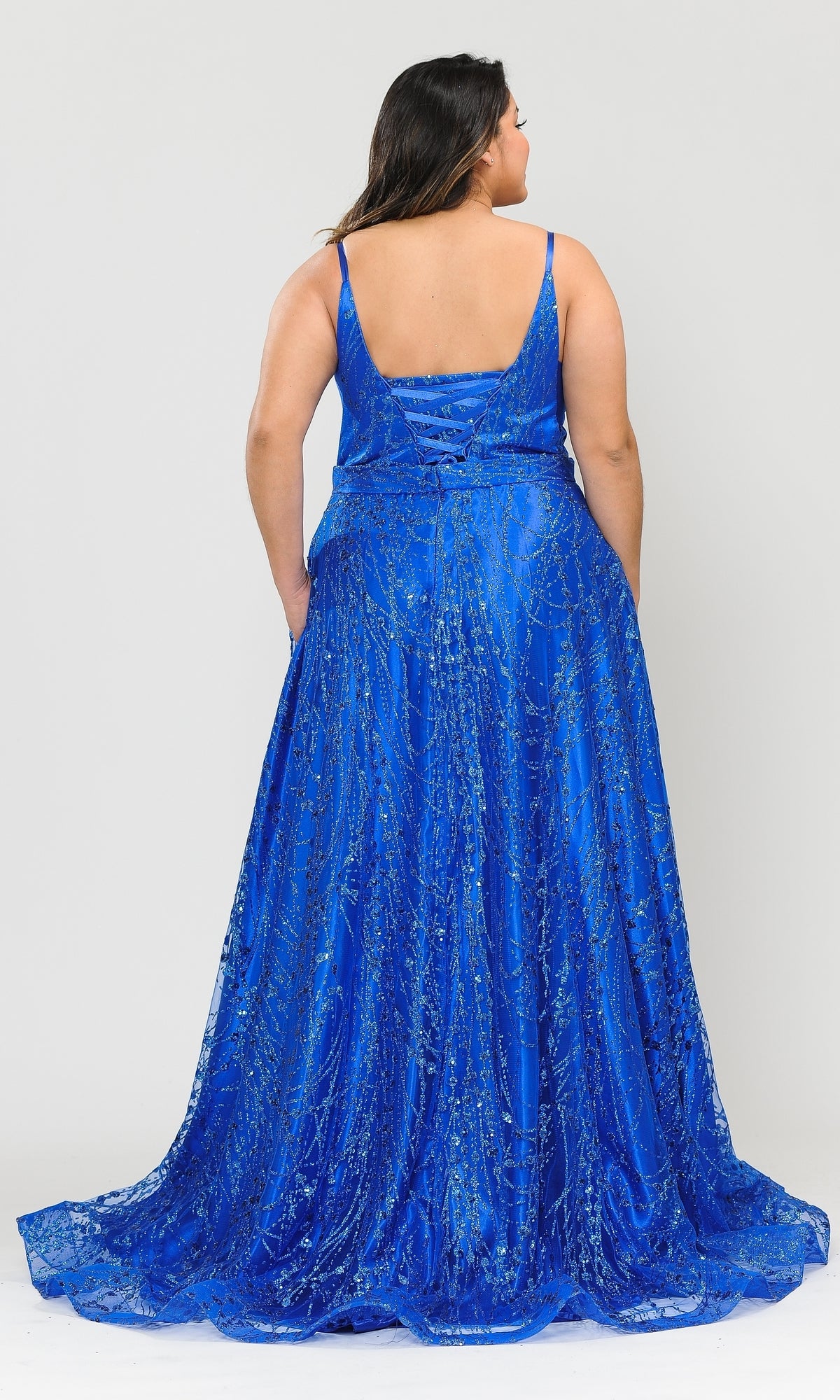 A woman faces away, wearing the Plus-Size Long Glitter-Print Prom Dress W1004 in bright blue, featuring shimmering intricate patterns and a stunning lace-up back.