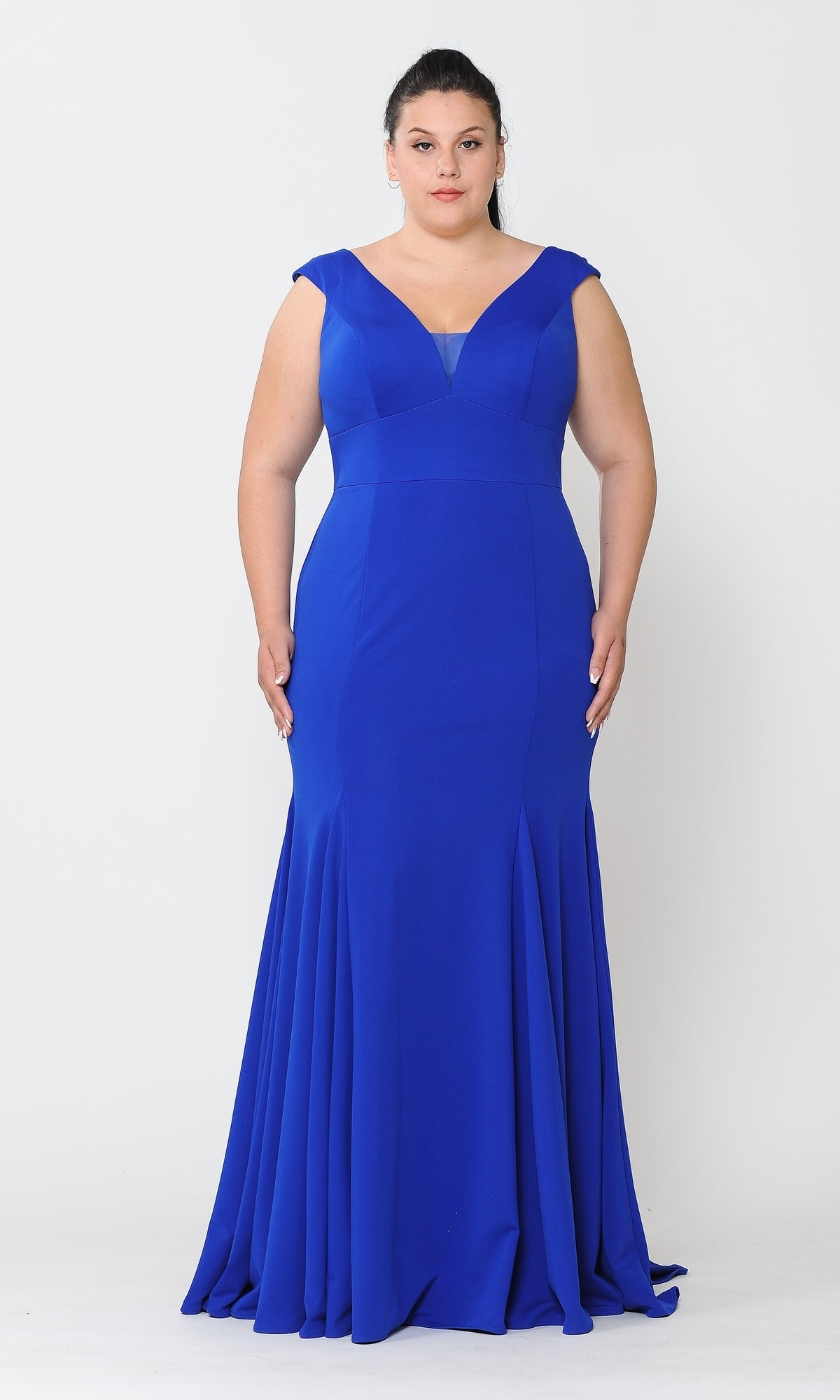 A woman in the Classic Sleeveless Plus-Size Long Prom Dress W1022, featuring a floor-length royal blue design with a V-neckline, stands against a plain white background.
