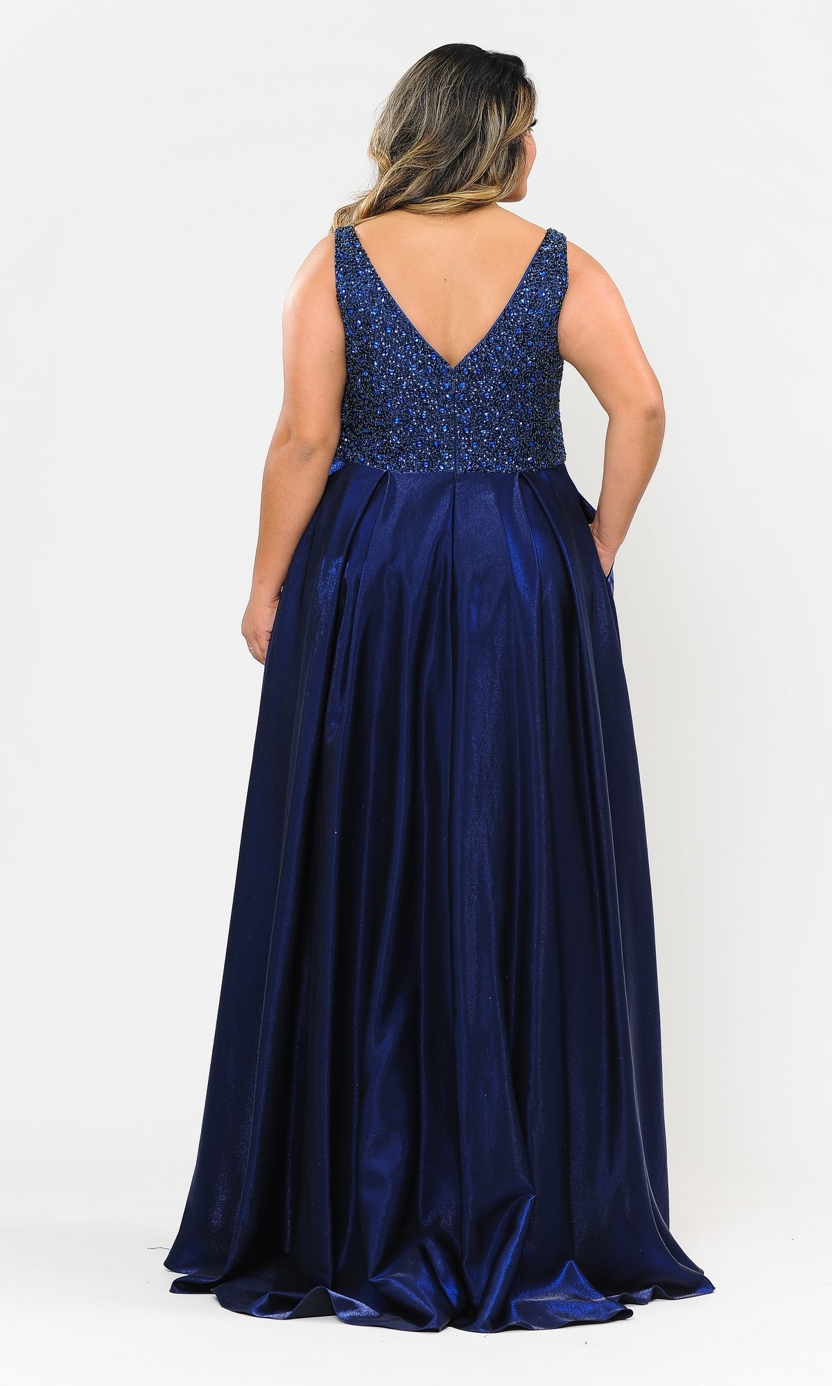 A woman faces away, wearing the Beaded-Bodice Plus-Size Long Prom Dress W1066—a sleeveless navy blue gown with a sequined bodice and V-back, perfect for prom or as an elegant evening dress.