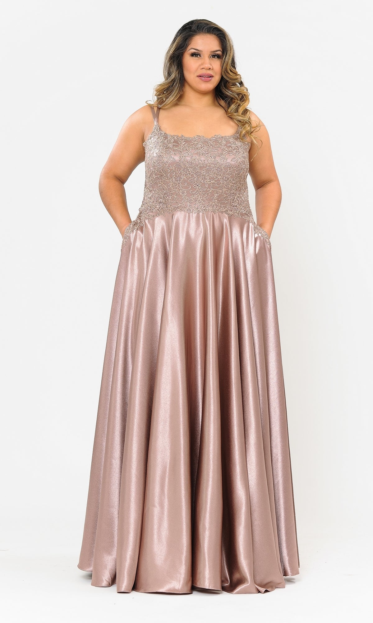 A woman wears the Lace-Bodice Plus-Size Long A-Line Prom Dress W1094, a sleeveless, floor-length pink satin gown with an embroidered lace bodice, standing against a plain white background.