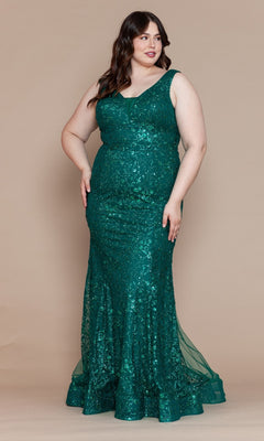A woman wearing the Plus-Size Long Glitter Mermaid Prom Dress W1136, a sleeveless, floor-length emerald green gown with glitter details, stands against a plain beige backdrop.