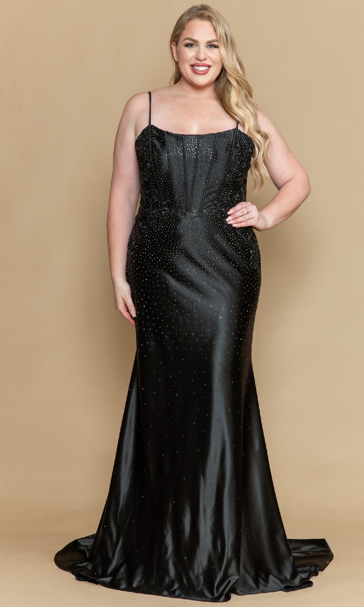 A woman poses against a beige background wearing the Plus-Size Tight Beaded Prom Dress: PolyUSA W1164—a long, black gown with thin straps and subtle bead embellishments.