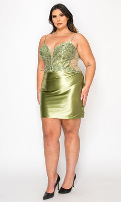 A woman wears the Plus-Size Short Party Dress: Poly USA W1176—an olive green cocktail dress with thin straps and a floral lace bodice—standing against a plain white background.