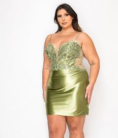 A woman wearing the Plus-Size Short Party Dress Poly USA W1176 in sage, featuring a deep V neckline and floral lace bodice, stands against a plain white background.
