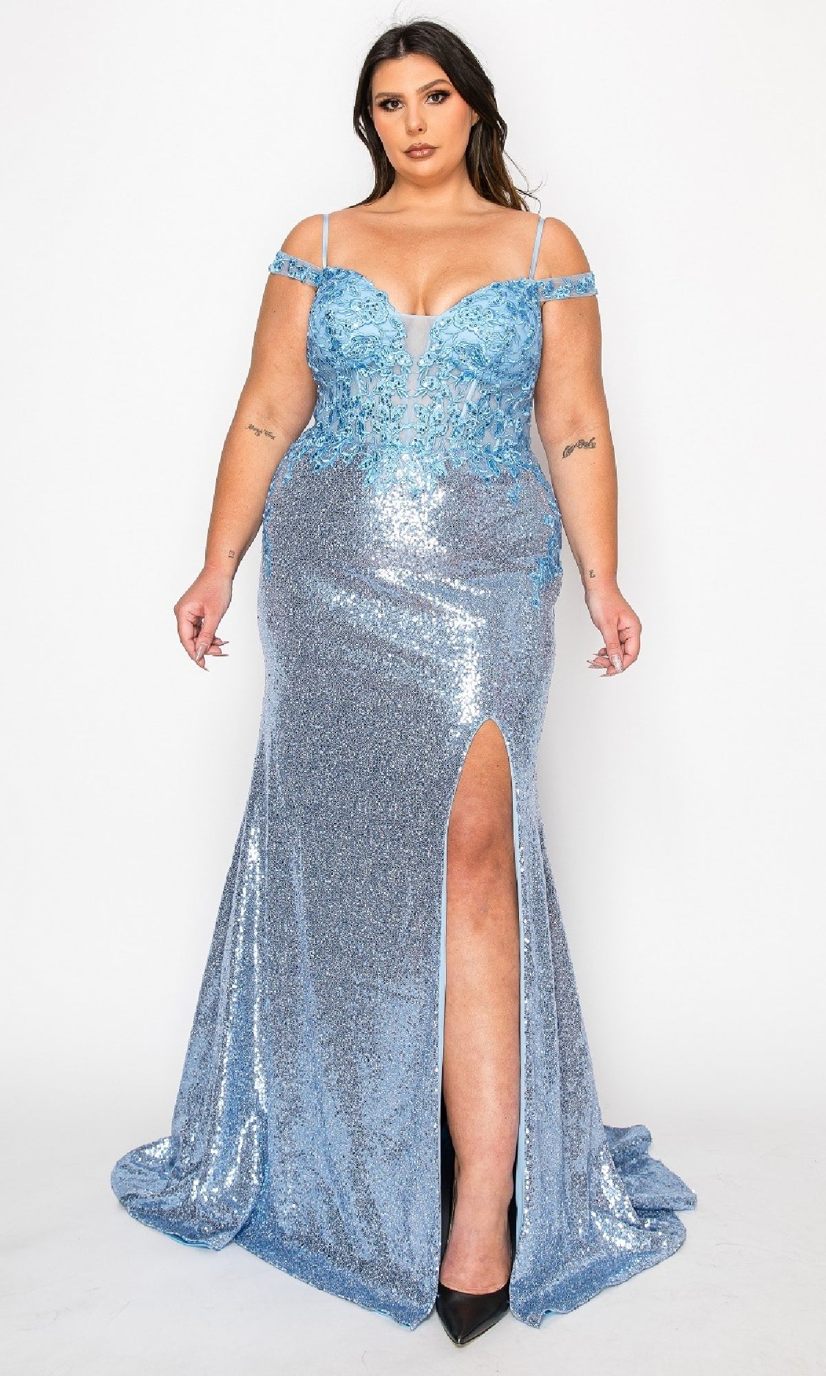 A woman models the Plus-Size Sequin Prom Dress with Slit: PolyUSA W1186, featuring sparkly light blue lace, an off-the-shoulder floral bodice, and a thigh-high slit, standing against a plain white background.