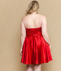 Red strapless dress with floral details on a beige background