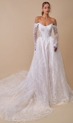 An elegant woman models the Andrea & Leo WL079 long wedding dress in off-white, showcasing its off-the-shoulder neckline, long lace sleeves, and sweeping train against a plain beige background.
