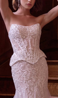 A woman stands indoors wearing the Long Wedding Dress: Andrea & Leo WL091—a strapless white gown featuring intricate beading, a fitted bodice adorned with floral embroidery, a flattering mermaid skirt, and delicate beaded lace corset detailing.