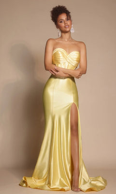 A woman models the Portia and Scarlett XO066 long formal dress in yellow, featuring a strapless satin design with a pleated crossover bodice, sweetheart neckline, and thigh-high slit, set against a beige background.