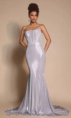 A woman stands against a plain beige background wearing the Portia and Scarlett XO097 long formal dress in silver, featuring a strapless neckline, fitted bodice, and flared train.
