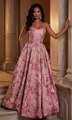 A woman stands by marble columns wearing the Portia and Scarlett XO180 long formal dress in fuchsia/gold, featuring a strapless design, floor-length floral pattern with gold accents, and an elegant A-line skirt.