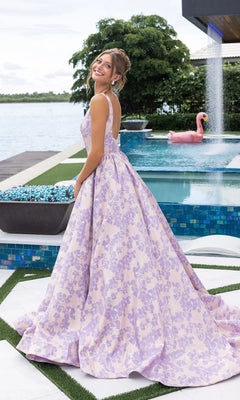 A woman in the Portia and Scarlett XO185 long formal dress smiles over her shoulder by a pool, with a flamingo float and waterfall feature in the background.