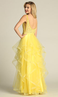 A woman wearing the Sheer-Sides Long Tiered Prom Dress (Chicas XR6006) with a lace bodice and layered tulle skirt stands facing away, looking over her shoulder and smiling.