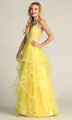Woman wearing the Chicas XR6006 Sheer-Sides Long Tiered Prom Dress, featuring a beaded v-neck bodice and ruffled a-line skirt, standing against a plain light background.