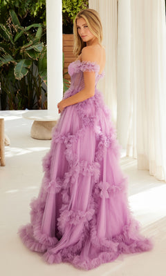 A woman stands indoors wearing the Sheer-Waist Off-Shoulder Long Prom Ball Gown Y1472, a floor-length lavender tulle dress with ruffle details; white pillars and greenery are featured in the background.