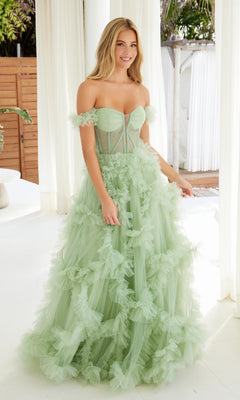 A woman stands indoors smiling at the camera, wearing the Sheer-Waist Off-Shoulder Long Prom Ball Gown Y1472—a stunning formal dress with ruffle details that radiates elegance.