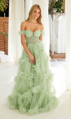 A woman stands indoors wearing the Sheer-Waist Off-Shoulder Long Prom Ball Gown Y1472, featuring a light green hue, ruffle details, and a sheer corset-style bodice for an ethereal ball gown look.