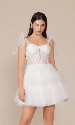A woman models the Sheer-Bodice Short White A-Line Party Dress Y858W, featuring a fitted bodice, sheer panels, and ribbon shoulder straps, standing against a plain beige background.