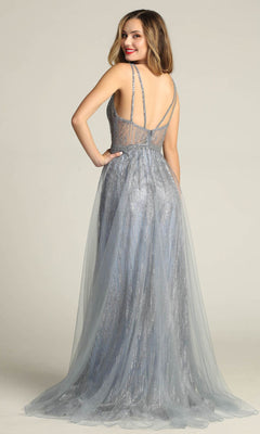Woman in the Sheer-Waist Long Sequin Prom Dress Chicas YG5021, a sleeveless silver-gray gown with thin straps and sheer details, poses smiling over her shoulder against a plain background.