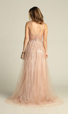 A woman faces away, wearing the Sheer-Waist Long Sequin Prom Dress (Chicas YG5021), a blush pink, floor-length gown with thin straps and sparkling sequin details, holding a small clutch in her right hand.