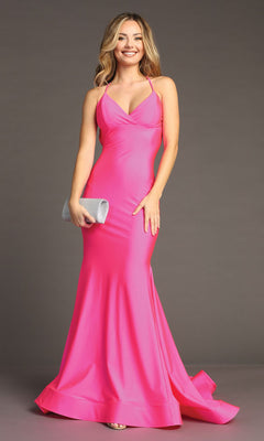 A woman in the Strappy Open-Back Long Prom Dress (Chicas YG5024), bright pink with an empire waist, holds a silver clutch and smiles at the camera against a plain gray backdrop.